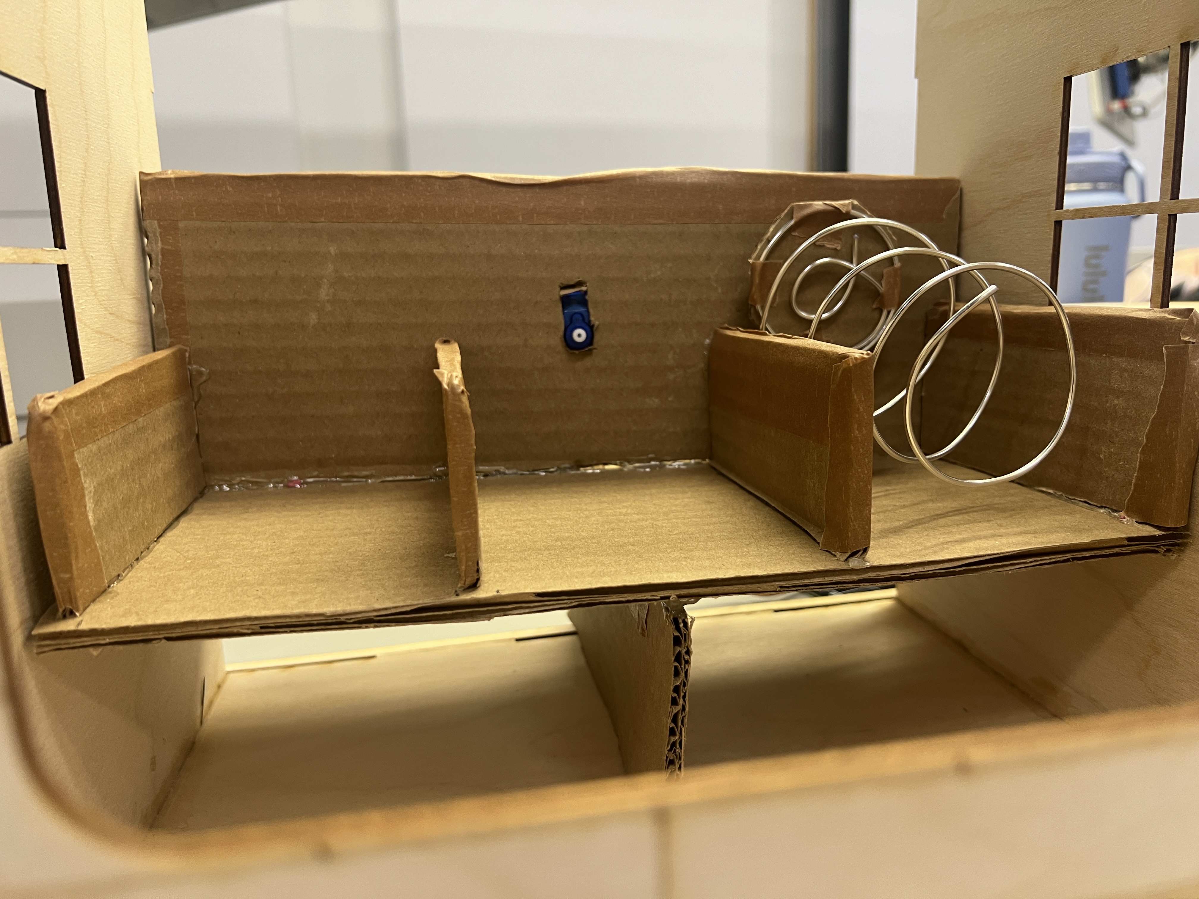 Interior layout experiment with cardboard dividers and spiral mechanisms.